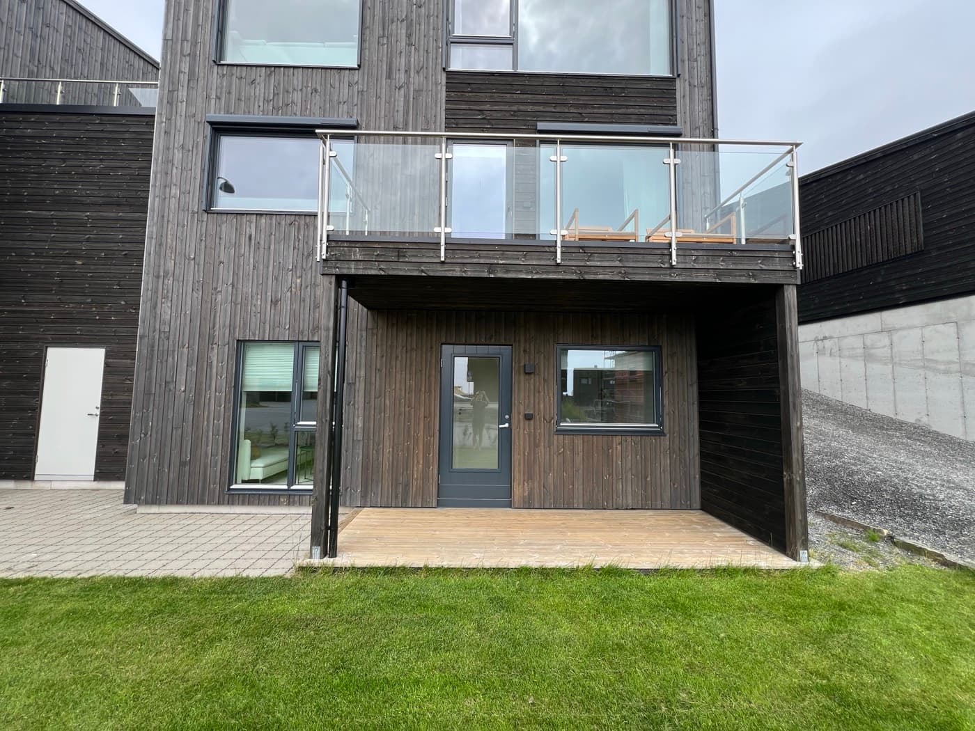 Inngangsdøren til leiligheten på husets forside, under balkongen.